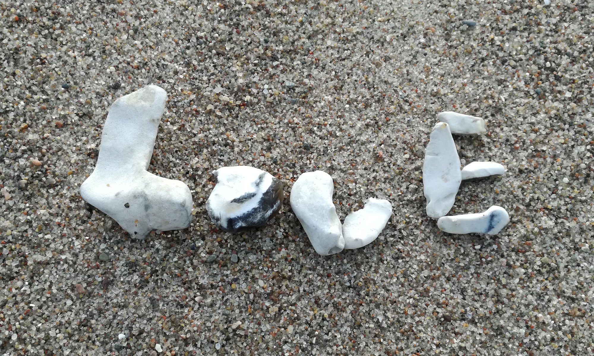 Steine am Strand bilden das Wort LOVE; Foto: Dorothee Dickmann